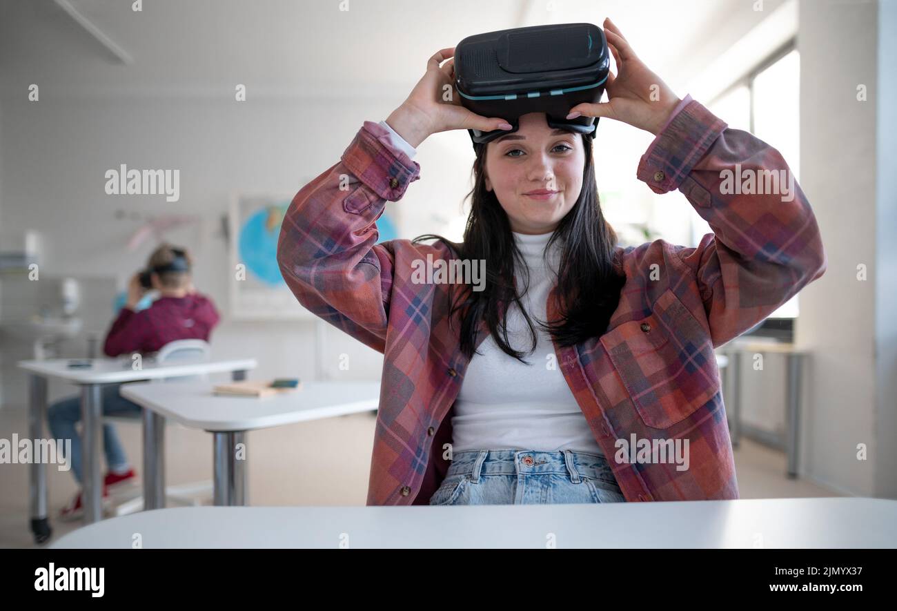 Glücklicher Schüler mit Virtual-Reality-Brille in der Schule im Informatikunterricht Stockfoto