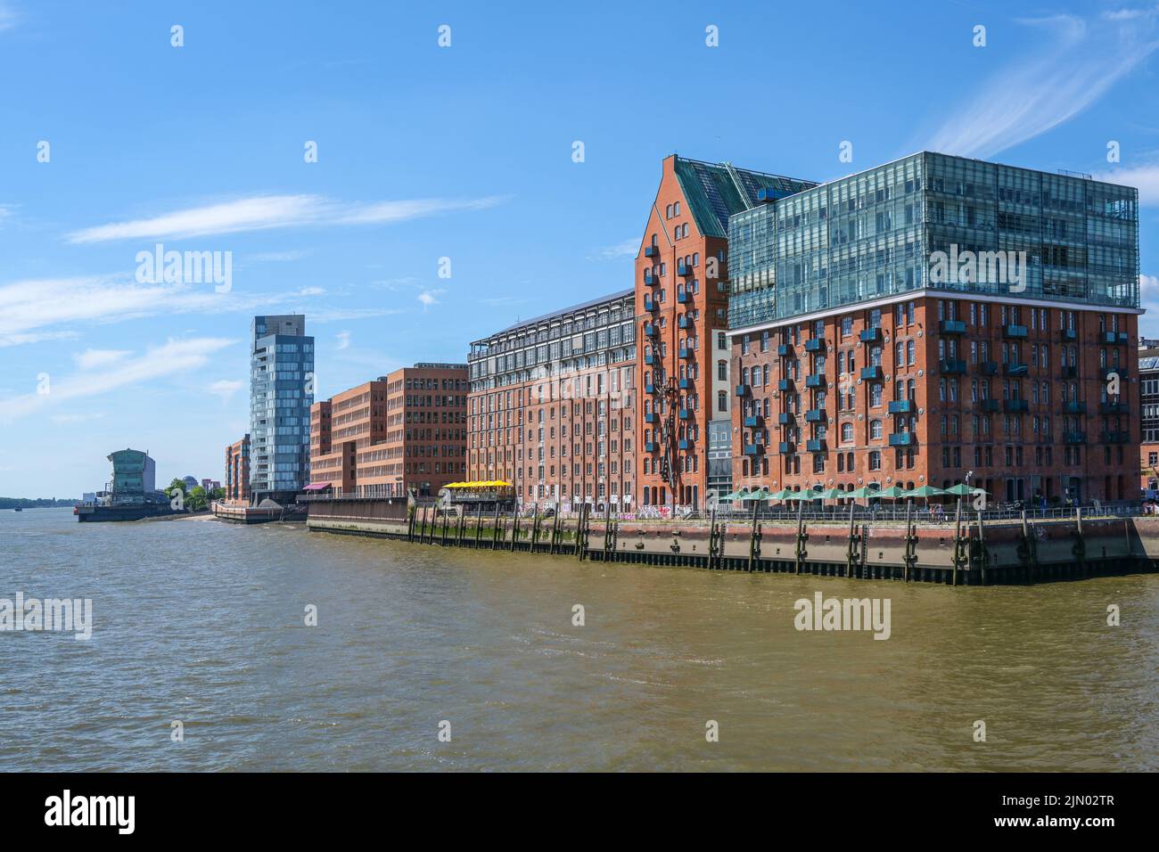 Hamburg, 3. August 2022: Moderne Gebäude aus rotem Backstein und Glas aus ehemaligen Lagerhäusern an der Elbe, blauer Himmel mit Kopierfläche, ausgewählt Stockfoto