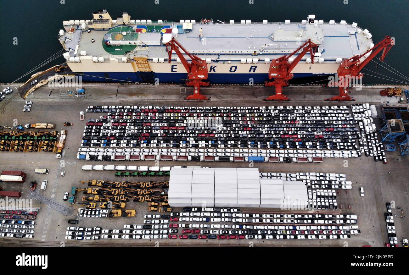 Qingdao. 7. August 2022. Luftaufnahme vom 7. August 2022 zeigt Nutzfahrzeuge vor ihrer Verladung auf ein Ro-Ro-Frachtschiff, das im Qingdao Hafen in Qingdao, der ostchinesischen Provinz Shandong, nach Afrika abfährt. Das Exportvolumen von Nutzfahrzeugen aus dem Hafen Qingdao ist in diesem Jahr im Vergleich zum Vorjahr um über 90 Prozent gestiegen. Quelle: Li Ziheng/Xinhua/Alamy Live News Stockfoto