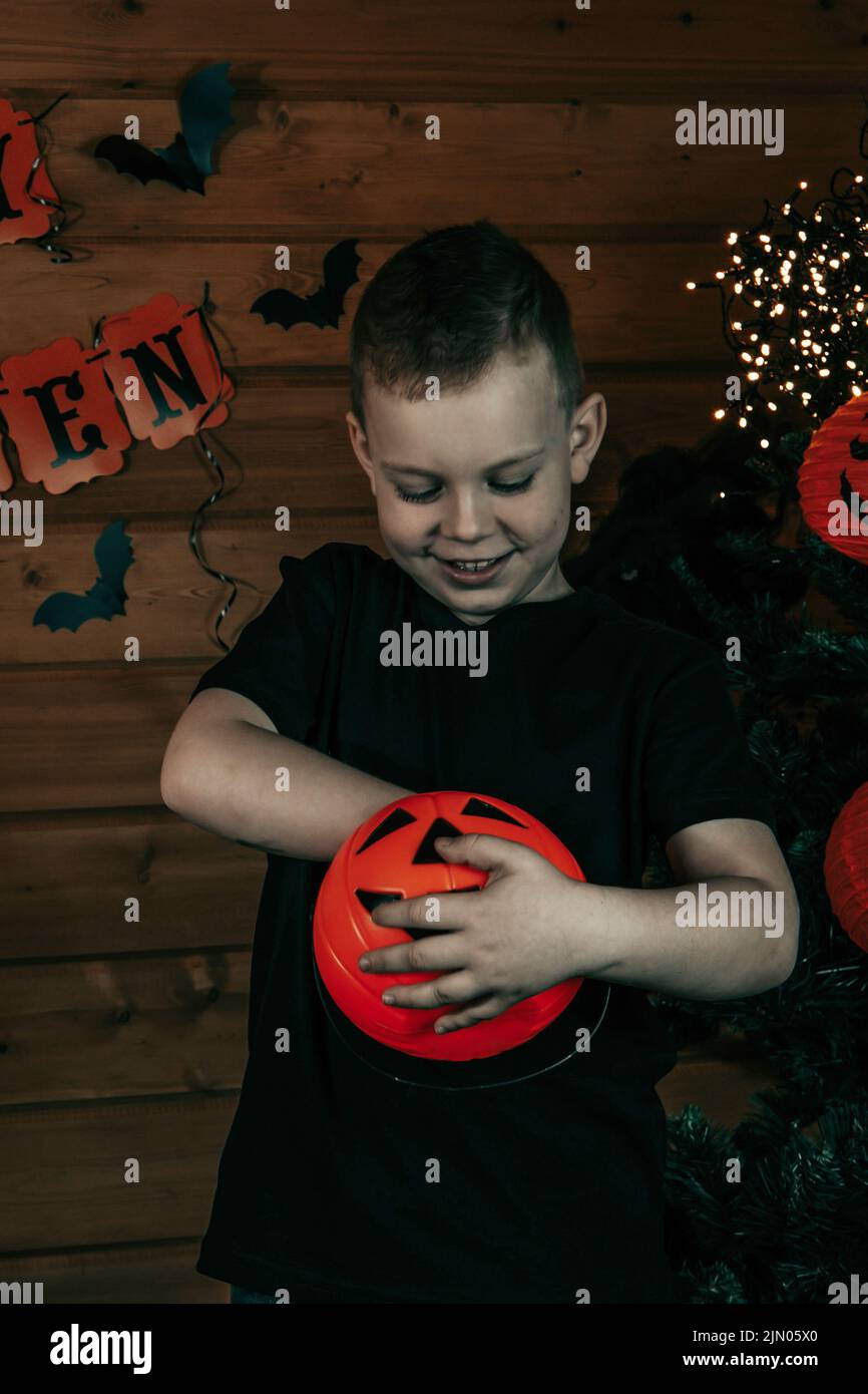 Halloween Kinder. Niedlicher kleiner Junge, Kind mit orangefarbenem Jack O Lantern Candy Eimer. Frohe Halloween. Halloween Hintergrund. Stockfoto