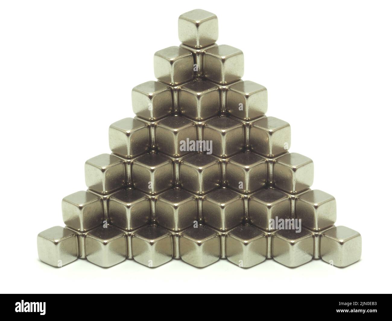 Metallische runde kubische Neodym-Magnete, die übereinander in einem Treppenmuster gestapelt sind. Isoliert auf weißem Hintergrund. Stockfoto