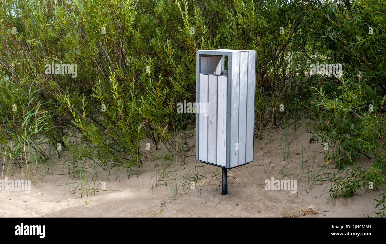 Ein weißer Müllcontainer am Ostseestrand. Lettland. Stockfoto