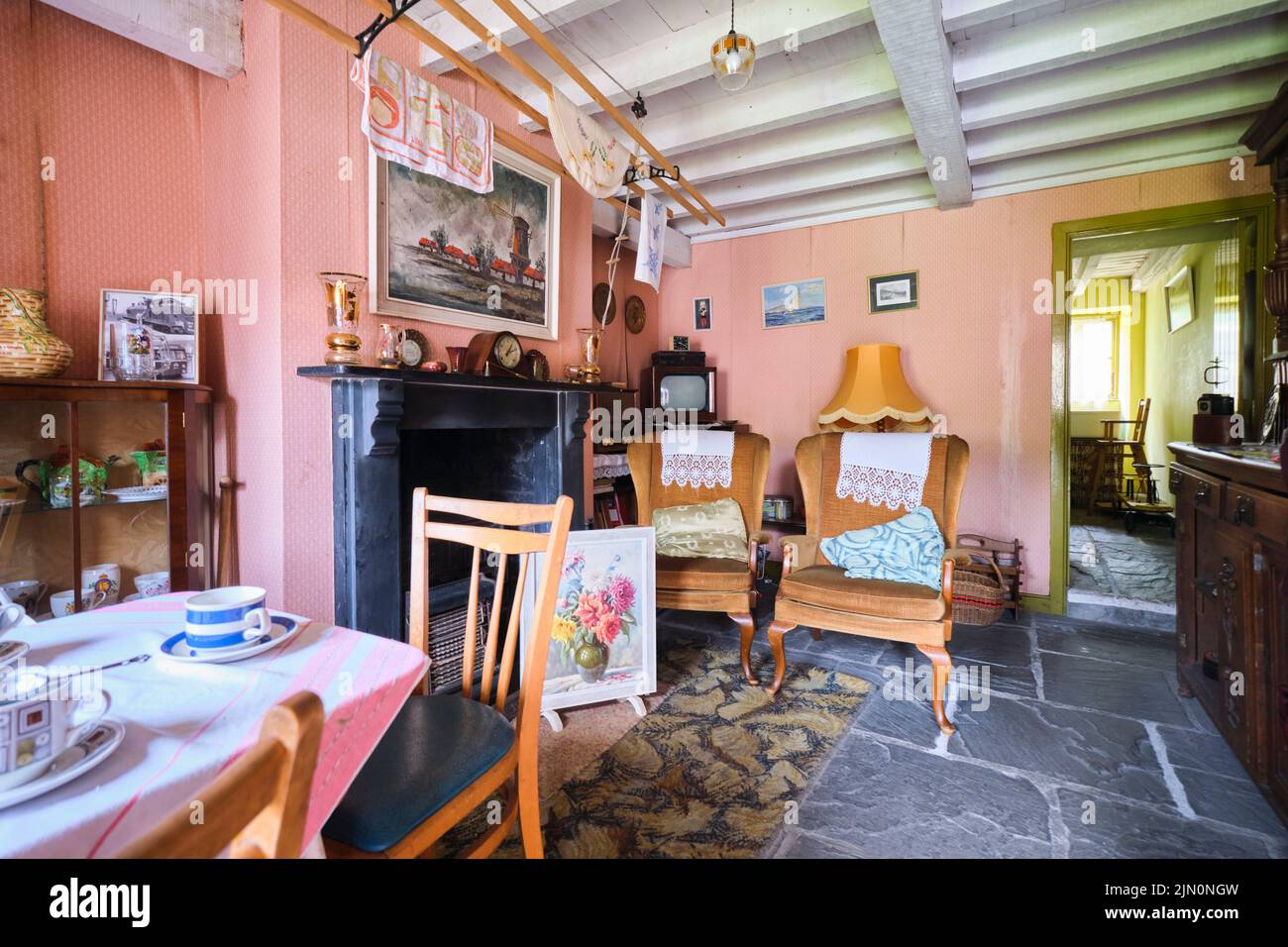 Ein typischer Wohnbereich mit Kamin zum Heizen. Hängestangen zum Trocknen von Wäsche. In einer Nachbildung eines typischen, generischen Arbeiterhauses aus dem Jahr 196 Stockfoto