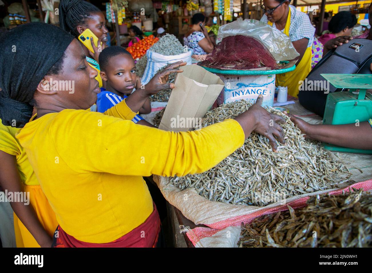 Kigali, Ruanda. 14.. Juli 2022. Ein Händler verpackt getrockneten Fisch mit einer Papiertüte auf dem Kimironko-Markt in Kigali, Ruanda, 14. Juli 2022. UM MIT "Feature: Ruanda macht Fortschritte beim Plastikverbot" zu GEHEN.Quelle: Cyril Ndegeya/Xinhua/Alamy Live News Stockfoto