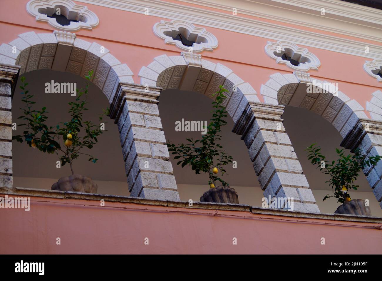 Ein herrliches rosafarbenes mediterranes Haus mit achter Galerie und Zitronenbäumen in Körben in der Stadt Limone sul Garda (Italien, Lombardei) Stockfoto