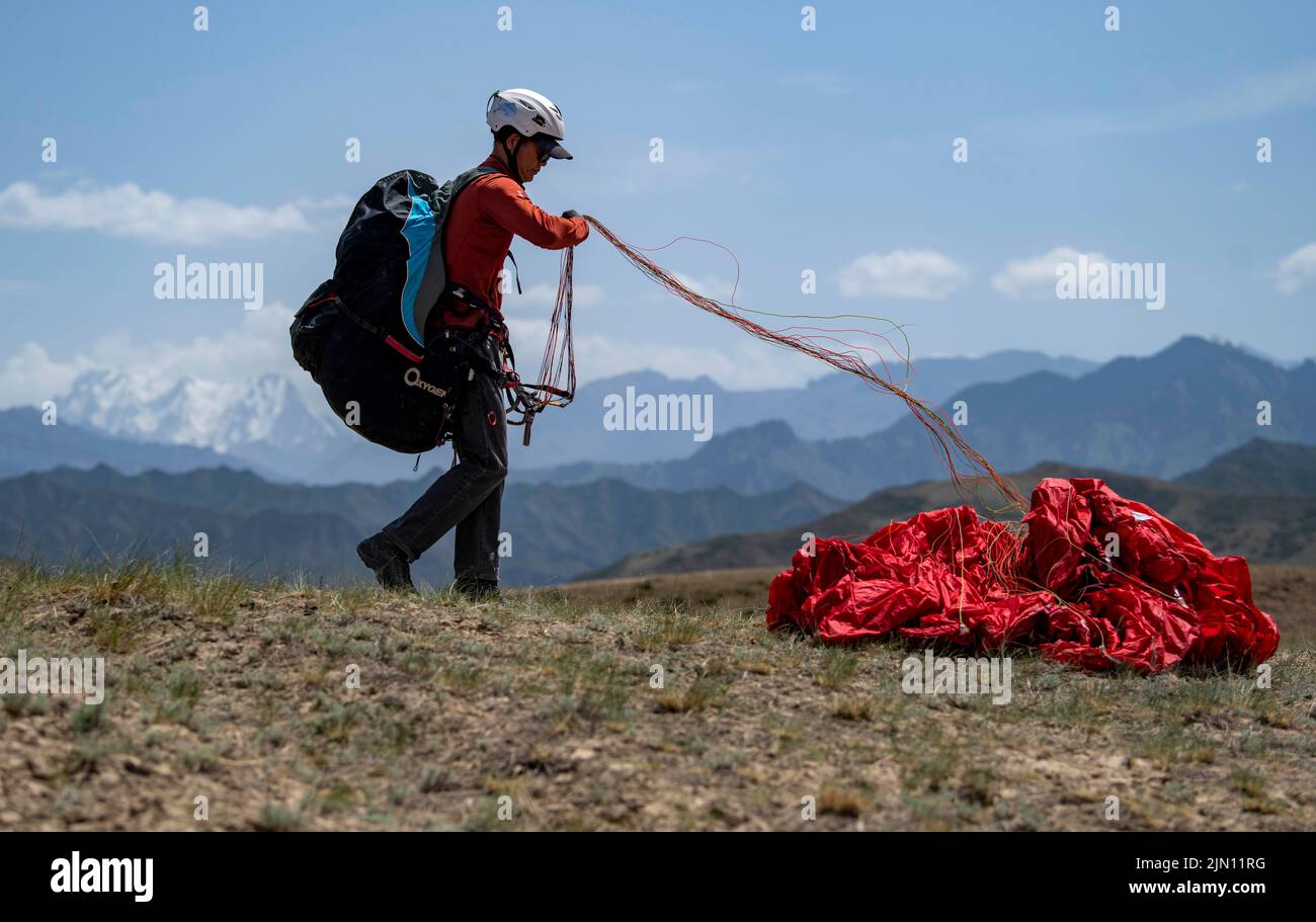 (220808) -- XINJIANG, 8. August 2022 (Xinhua) -- Chen Ruifeng praktiziert Gleitschirmfliegen im südlichen Vorort Urumqi, nordwestlich der Autonomen Region Xinjiang Uygur in China, 24. Mai 2022. Der 52-jährige Chen Ruifeng, der in Xinjiang geboren wurde, ist ein Paragliding-Amateur. Er sagt, dass er sich wie mit seinen eigenen Flügeln fühlt, wenn der Gleitschirm geöffnet wird. Im Jahr 2016 begann Chen Ruifeng, Gleitschirmfliegen zu üben. Später trat er einem lokalen Verein bei und erhielt nach dem Training seine Flugbescheinigung. Als Outdoor-Enthusiast engagiert er sich auch für Trailrunning, Bergsteigen und Eisklettern. Seiner Meinung nach das einzigartige Gelände von Xin Stockfoto