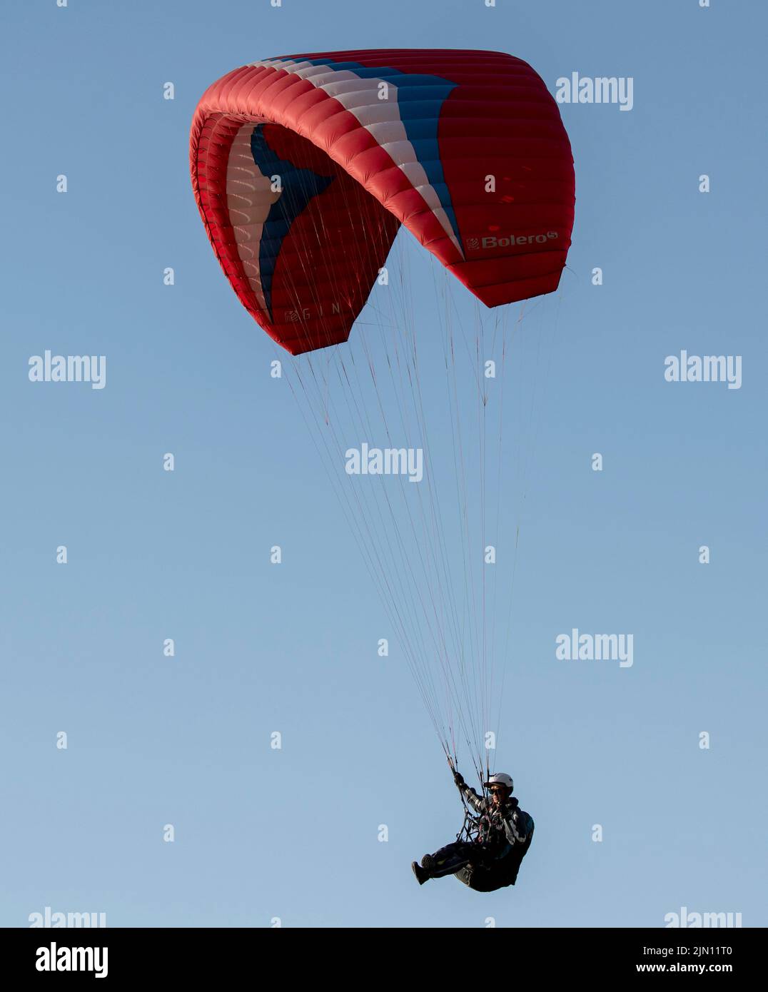 (220808) -- XINJIANG, 8. August 2022 (Xinhua) -- Chen Ruifeng gleitet am Himmel über dem südlichen Vorort Urumqi, der nordwestlichen Autonomen Region Xinjiang Uygur, am 29. Mai 2022. Der 52-jährige Chen Ruifeng, der in Xinjiang geboren wurde, ist ein Paragliding-Amateur. Er sagt, dass er sich wie mit seinen eigenen Flügeln fühlt, wenn der Gleitschirm geöffnet wird. Im Jahr 2016 begann Chen Ruifeng, Gleitschirmfliegen zu üben. Später trat er einem lokalen Verein bei und erhielt nach dem Training seine Flugbescheinigung. Als Outdoor-Enthusiast engagiert er sich auch für Trailrunning, Bergsteigen und Eisklettern. Seiner Meinung nach das einzigartige Gelände von Xinji Stockfoto