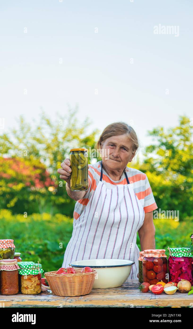 Ältere Frau, die Gemüse in Gläsern konservieren. Selektiver Fokus. Essen. Stockfoto