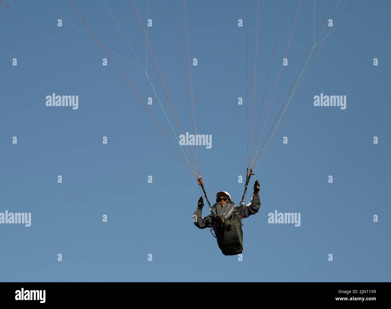 (220808) -- XINJIANG, 8. August 2022 (Xinhua) -- Chen Ruifeng gleitet am Himmel über dem südlichen Vorort Urumqi, der nordwestlichen Autonomen Region Xinjiang Uygur, am 29. Mai 2022. Der 52-jährige Chen Ruifeng, der in Xinjiang geboren wurde, ist ein Paragliding-Amateur. Er sagt, dass er sich wie mit seinen eigenen Flügeln fühlt, wenn der Gleitschirm geöffnet wird. Im Jahr 2016 begann Chen Ruifeng, Gleitschirmfliegen zu üben. Später trat er einem lokalen Verein bei und erhielt nach dem Training seine Flugbescheinigung. Als Outdoor-Enthusiast engagiert er sich auch für Trailrunning, Bergsteigen und Eisklettern. Seiner Meinung nach das einzigartige Gelände von Xinji Stockfoto