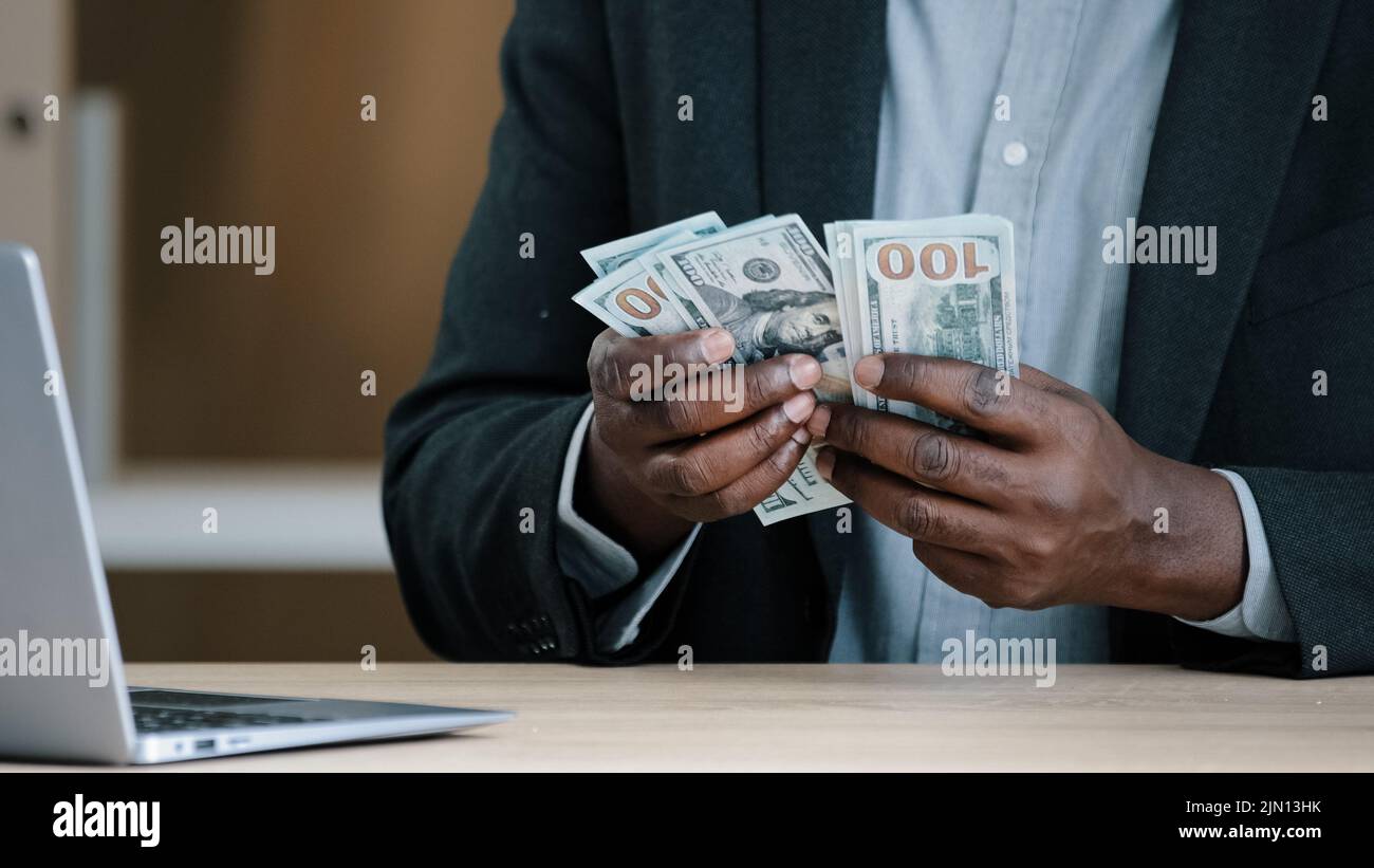 Nahaufnahme afrikanische alte männliche Hände mit Geld im Büro unkenntlich biracial Erfolg wohlhabender Geschäftsmann hält Dollar Gehälter Buchhaltung Einsparungen Stockfoto