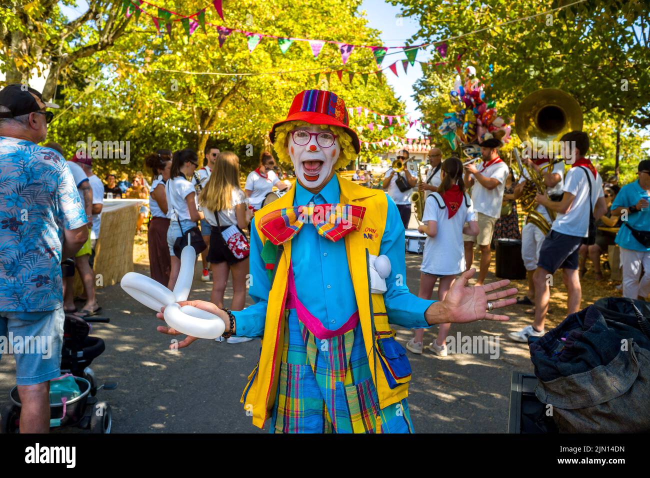 Ein Clown, umgeben von Menschen und der Band. Illustration des Dorffludes von Saint-Sardos. Frankreich, Saint-Sardos am 7. August 2022. Foto Patricia Huchot-Boissier/ABACAPRESS.COM Stockfoto