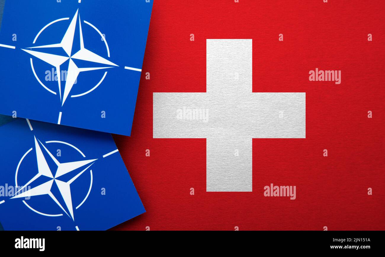 LONDON, Großbritannien - 2022. August: Logo der NATO-Organisation für den Nordatlantikvertrag auf einer Schweizer Flagge Stockfoto