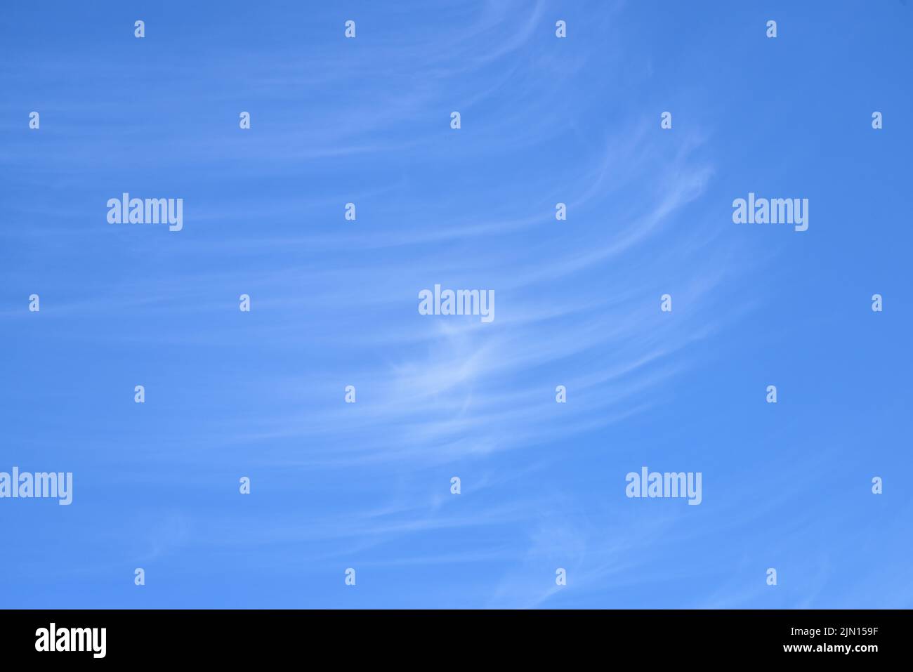 Flauschige weiße Zirruswolken am klaren blauen Himmel Stockfoto