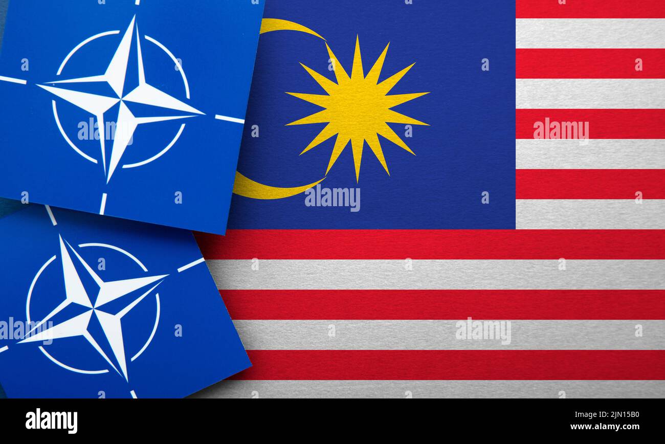 LONDON, Großbritannien - 2022. August: Logo der NATO-Organisation für den Nordatlantikvertrag für ein Militärbündnis auf einer malaysischen Flagge Stockfoto
