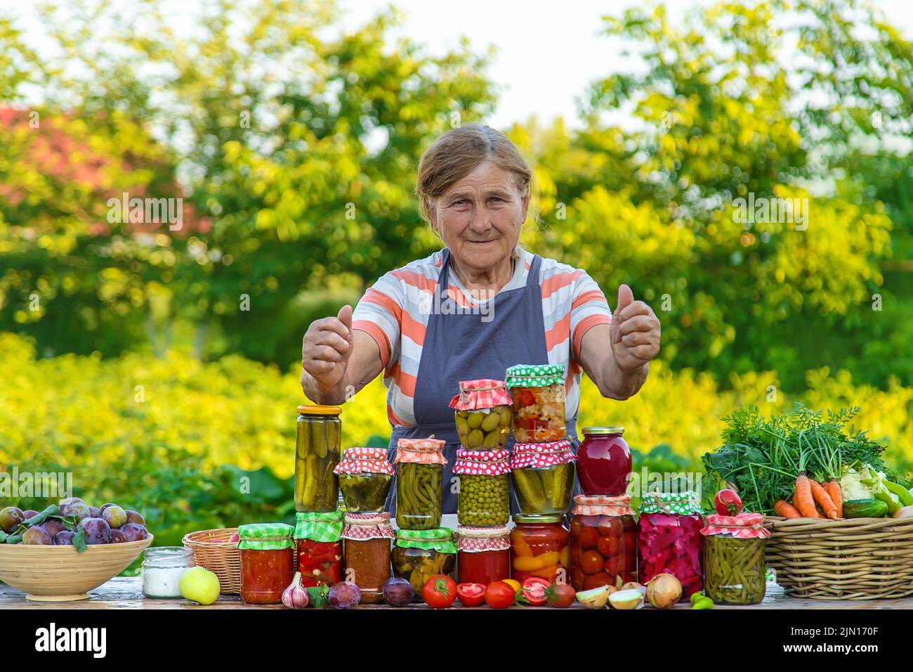Ältere Frau, die Gemüse in Gläsern konservieren. Selektiver Fokus. Essen. Stockfoto