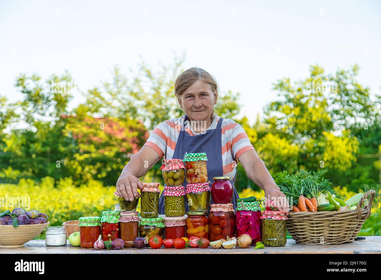 Ältere Frau, die Gemüse in Gläsern konservieren. Selektiver Fokus. Essen. Stockfoto