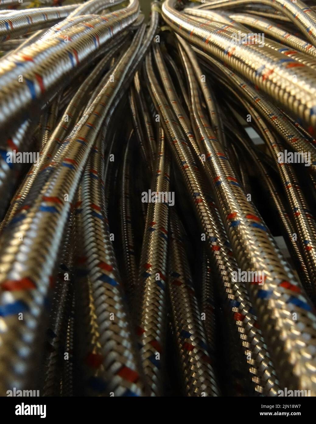 Stahlbeschlag-Schläuche, die am Regal in der Sanitäranlage hängen Stockfoto