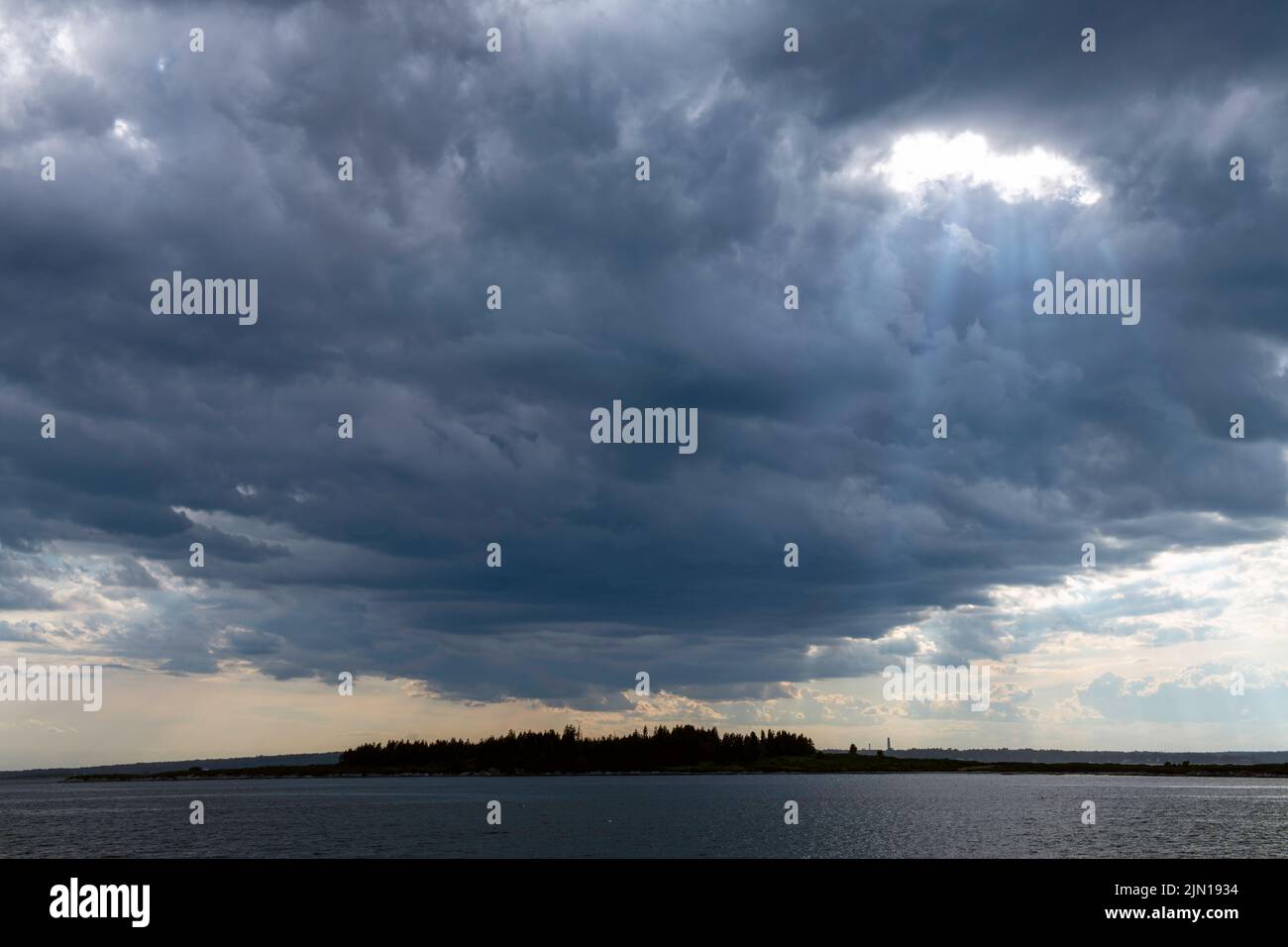 8. Juli 2022. 5:41pm Uhr. Sturm Wolken auf dem Weg über Whaleboat Island. Blick von Barnes Island. Casco Bay, Maine. Regensturm-Serie Stockfoto