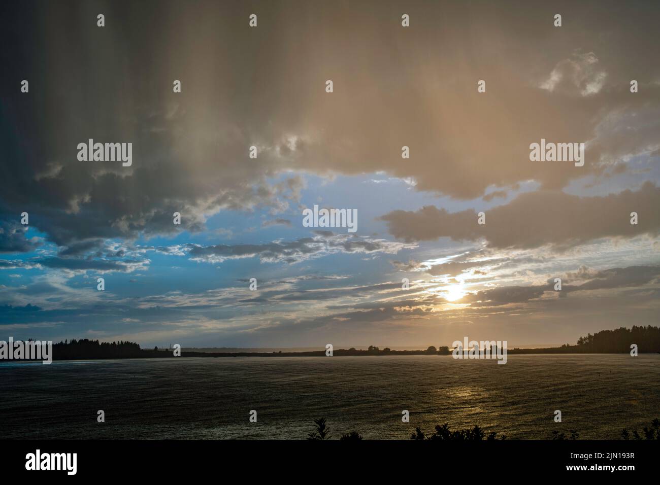 8. Juli 2022. 7:45:50 Uhr. Regen, blauer Himmel und Sonne, alles zusammen. Blick von Barnes Island. Casco Bay, Maine. Rain Storm Series. Stockfoto