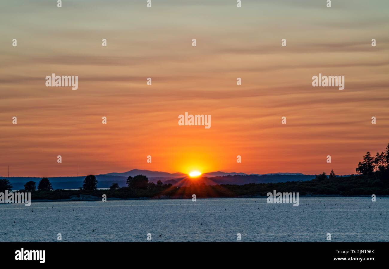 9. Juli 2022. 8:17 Uhr. Blick auf die Presidential Range bei Sonnenuntergang. Barnes Island. Casco Bay. Maine. Stockfoto
