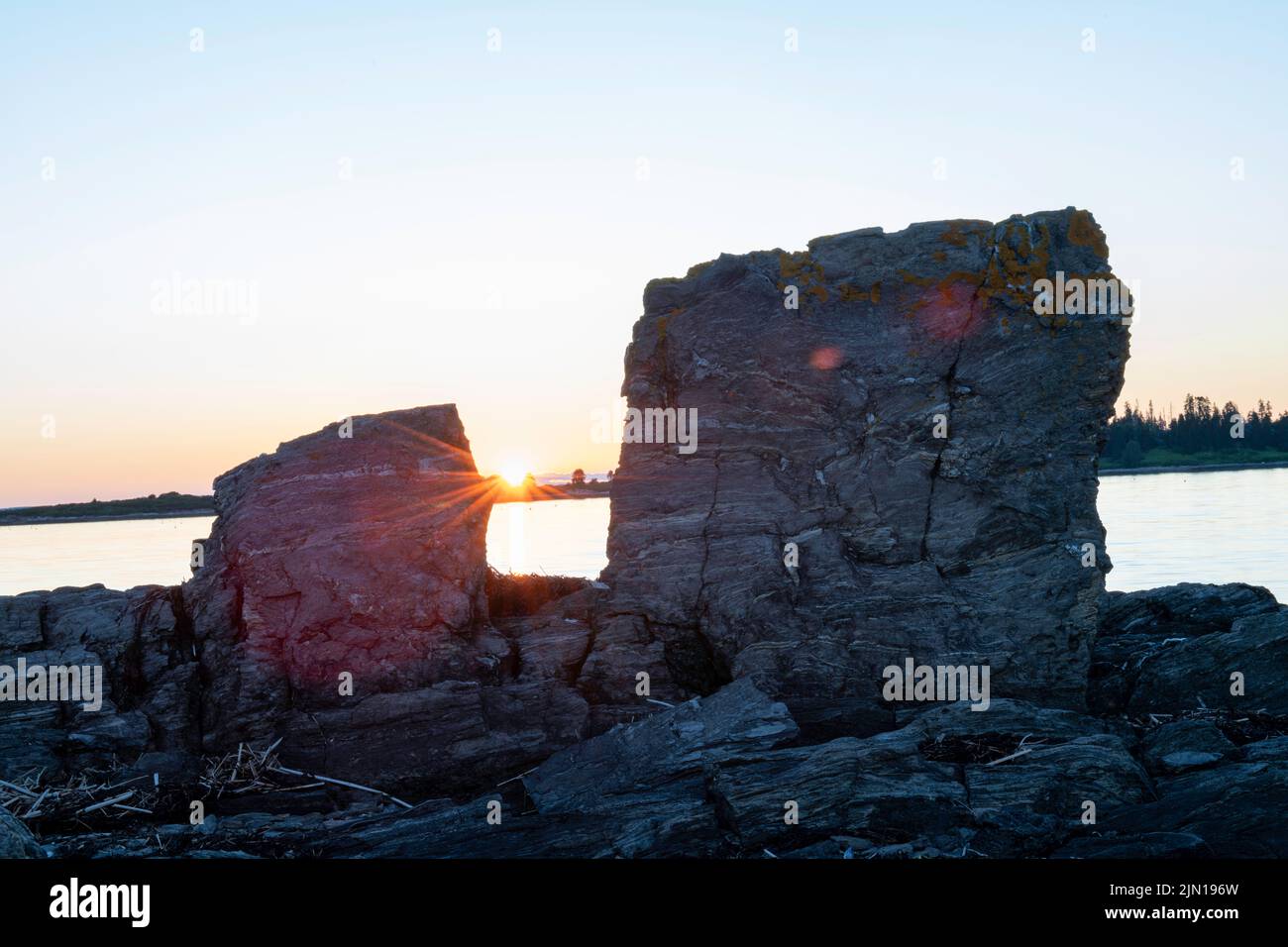 6. Juli 2022. 8:16:28 Uhr. Zwei Felsen bei Sonnenuntergang. Barnes Island. Casco Bay, Maine. Stockfoto