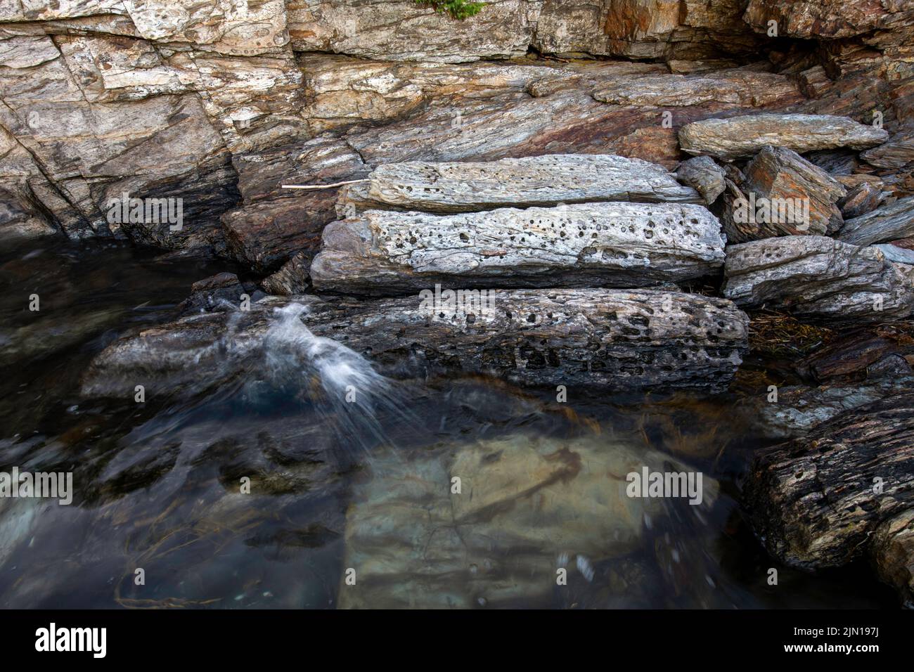 10. Juli 2022. 7:35pm Uhr. Felsen bei Flut auf Barnes Island. Casco Bay. Maine. Gezeitenserie. Zweiter von zwei. Stockfoto