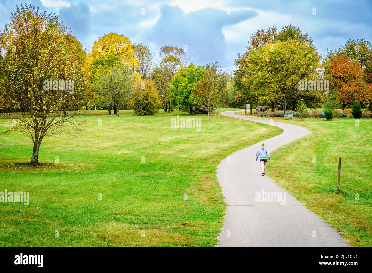 Eine Person, die im Herbst auf dem Trail in Arboretum in Lexington, Kentucky, unterwegs ist Stockfoto