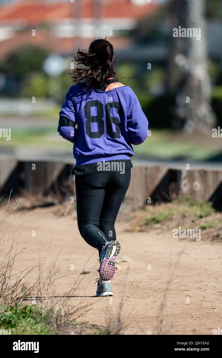 Das Bild einer Frau auf ihrem Morgenlauf. Trail Runner, Beach Runner, San Francisco, Kalifornien, Westküste, Gesundheit, Wellness, Bewegung Stockfoto