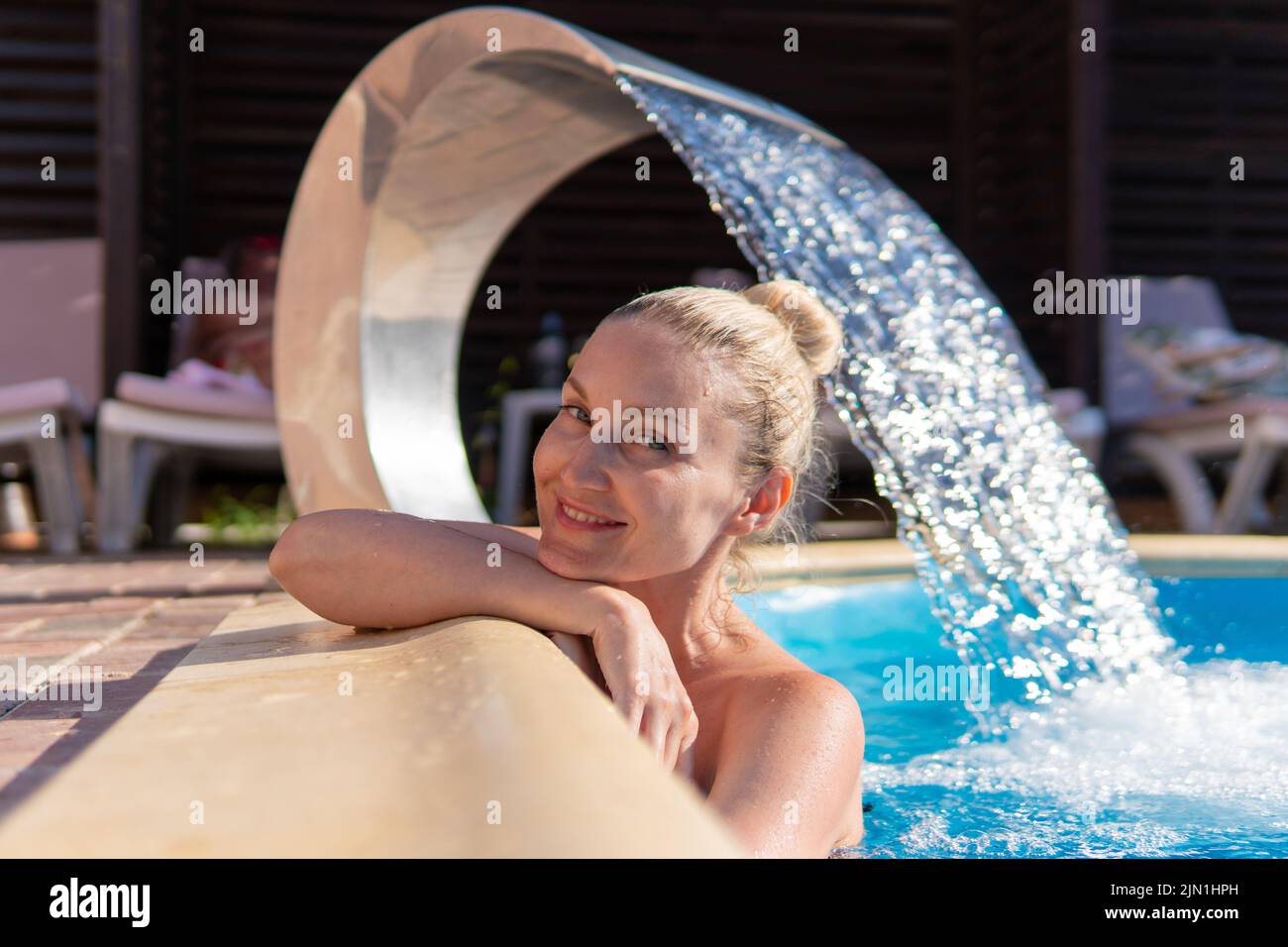 Lächelnd Pool Wasserfall Frau schwimmen jung schöne Luxus Leben entspannen, Konzept Wellness Körper für Hautpflege und spritzt Aqua, Brunette Tropfen Stockfoto