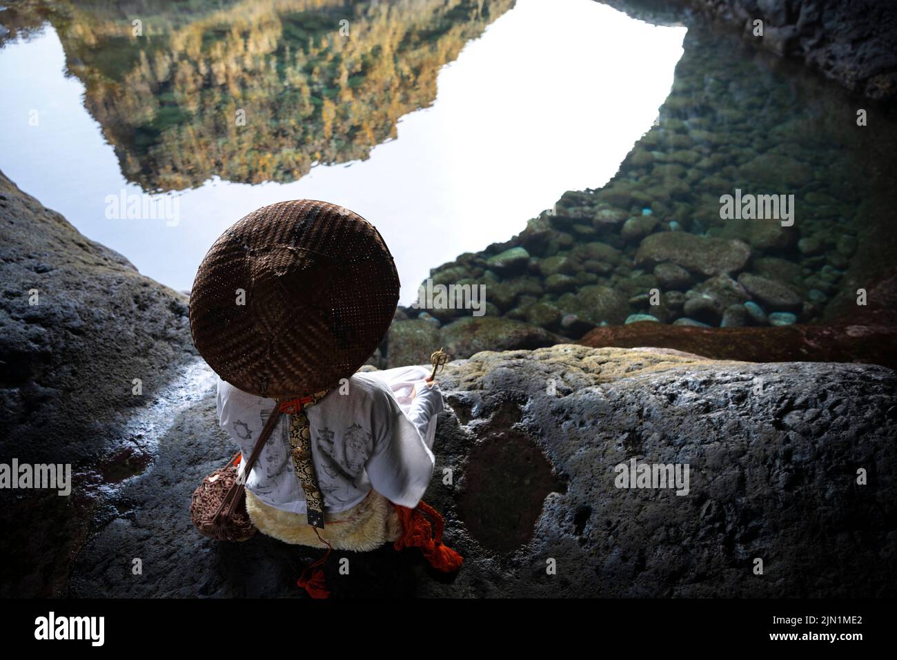 Der Mönch Shugendo sitzt in einer Höhle und meditiert, während er auf das offene Meer blickt Stockfoto