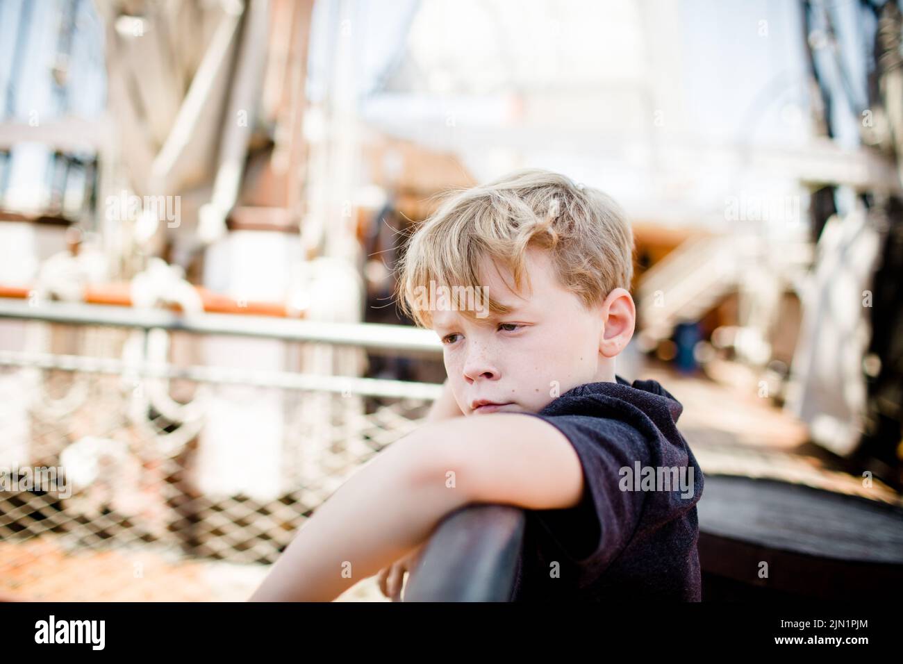 Acht Jahre alter Junge, der das Segelboot im Maritime Museum in San Diego erkundet Stockfoto