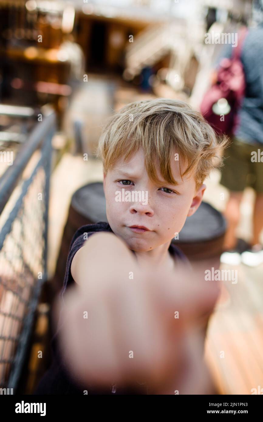 Achtjähriger Junge, der in San Diego Hand vor die Kamera hält Stockfoto