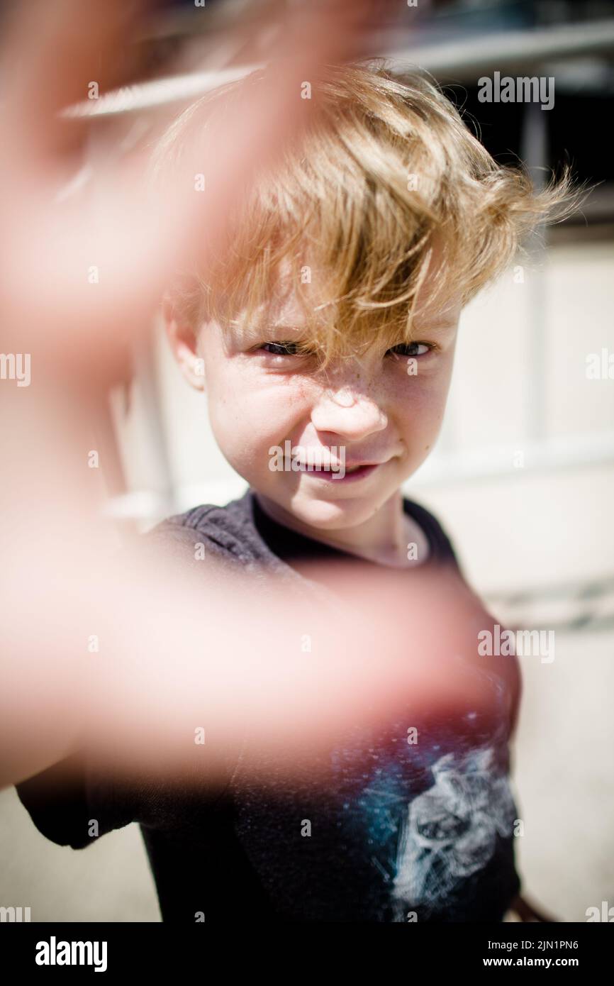 Achtjähriger Junge, der in San Diego die Hand vor die Kamera legt Stockfoto