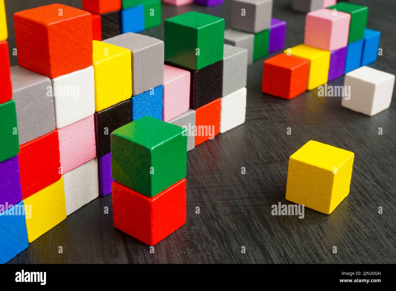 Mehrfarbige Würfel auf der Oberfläche als Symbol für Komplexität, Vielfalt und Integration. Stockfoto