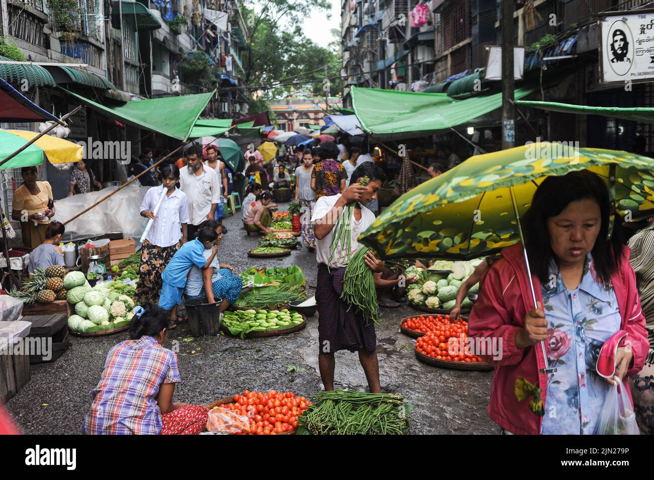 28.07.2013, Yangon, Myanmar, Asien - die Marktszene zeigt Menschen, die während der Regenzeit auf einem Straßenmarkt im Stadtzentrum Gemüse und Lebensmittel kaufen. Stockfoto