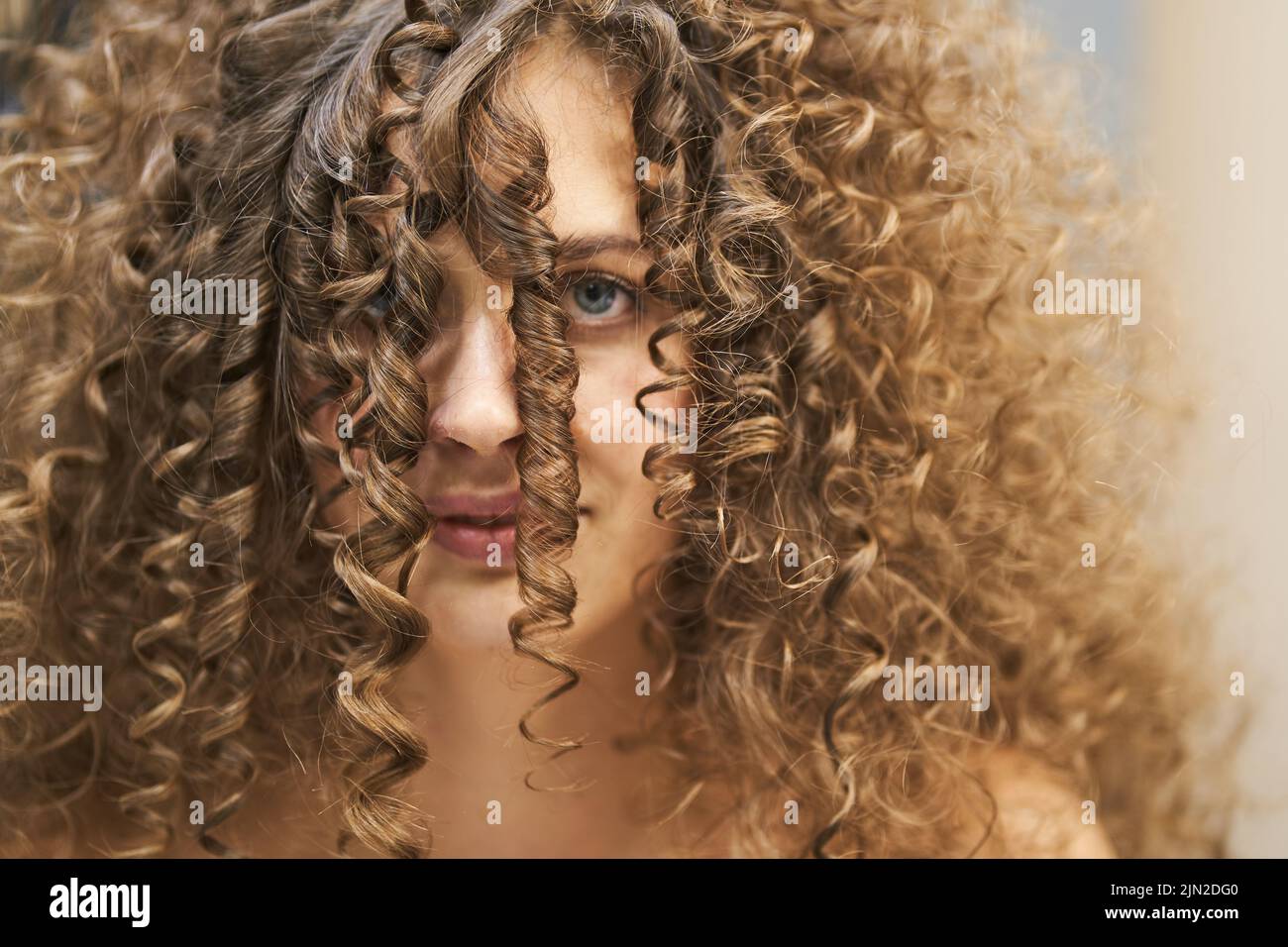 Die natürliche Schönheit der Frauen, das Konzept des Glücks. Ein schönes Porträt einer kaukasischen Frau mit sauberer, gesunder Haut und Afro-Locken. Lockige Locken im Gesicht. Hochwertige Fotos Stockfoto