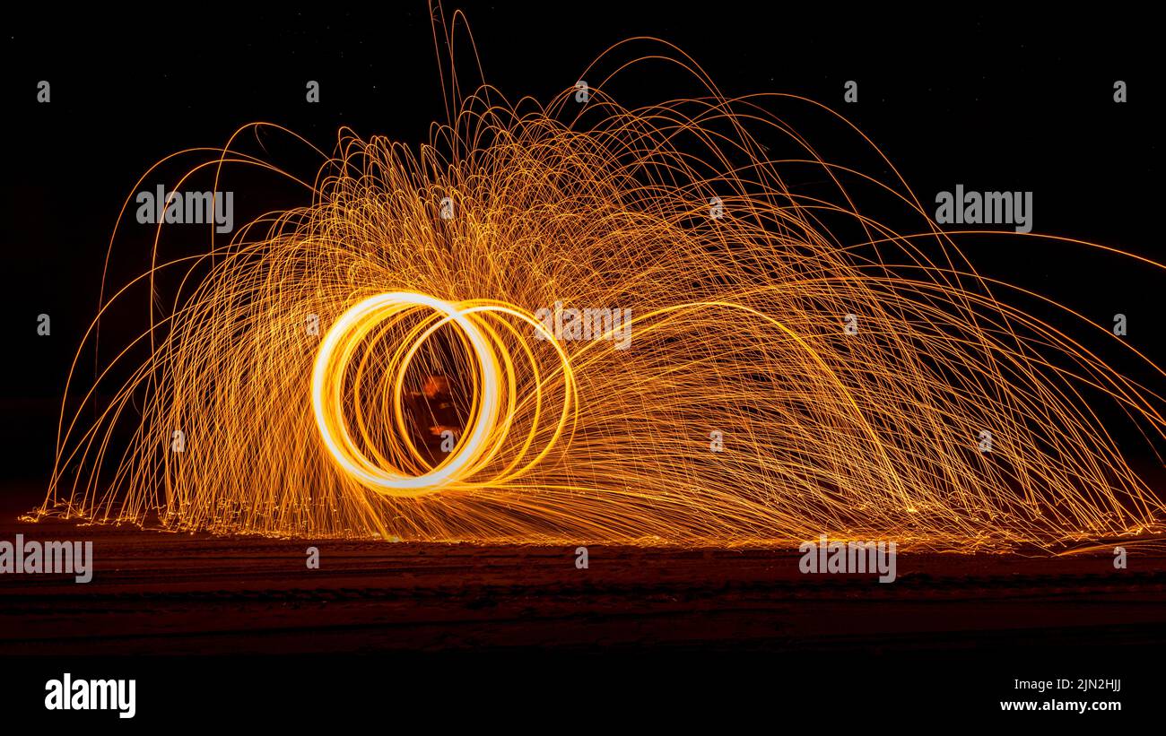 Nachtaufnahmen von Lichtmalerei am Strand mit der Milchstraße im Hintergrund. Stockfoto