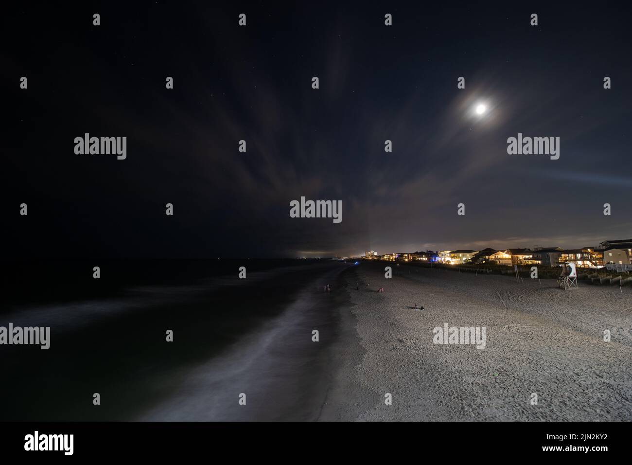 Strandliebhaber erholen sich nachts am Wrightsville Beach in North Carolina. Stockfoto