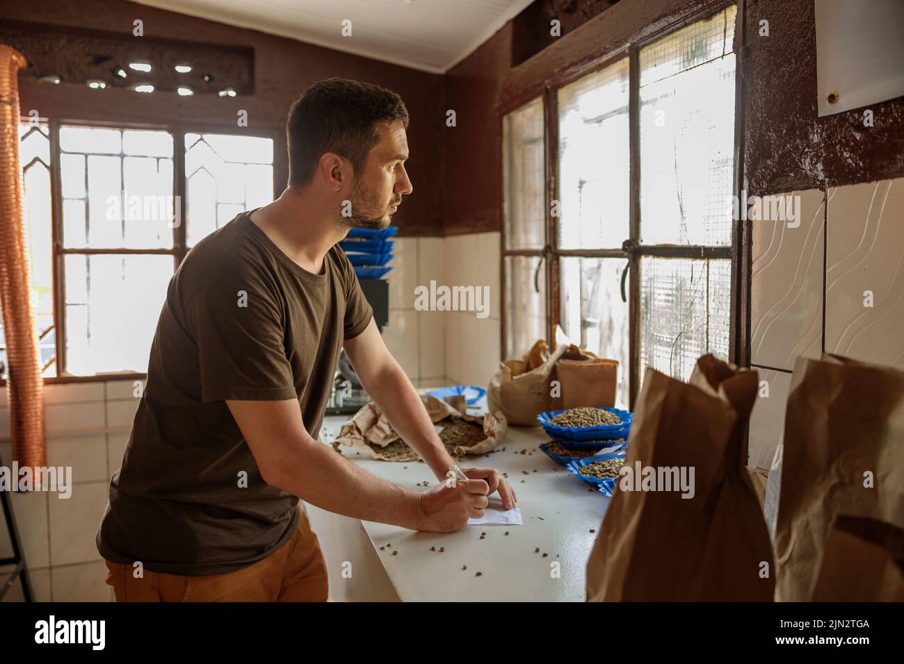 Professioneller männlicher Kaffeeverkoster, der bei der Produktion in Afrika arbeitet Stockfoto