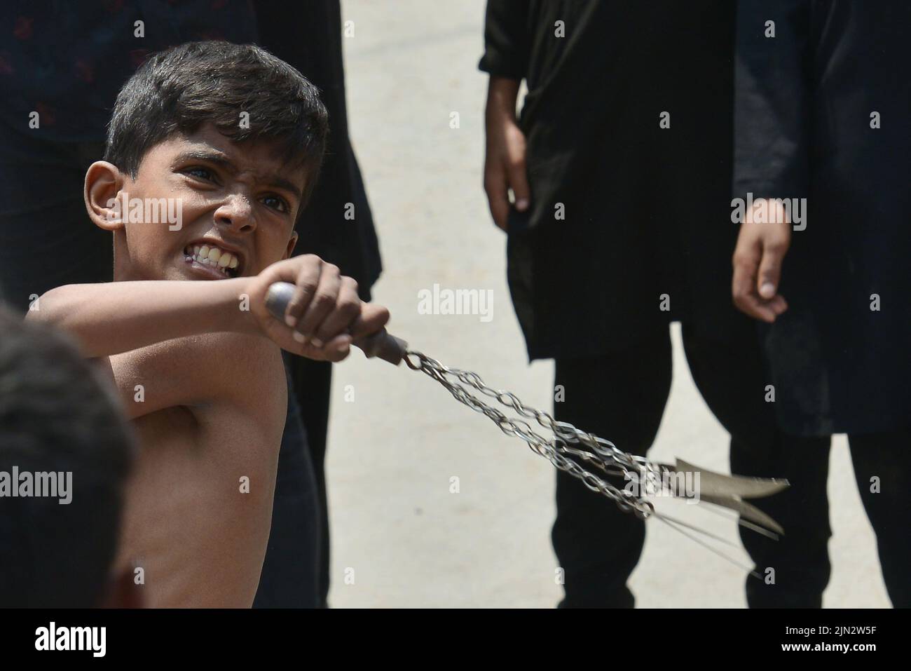 Lahore, Punjab, Pakistan. 8. August 2022. Ein junger pakistanischer schiitischer Muslim geißelte sich während einer Muharram-Prozession am neunten Tag von Aschura. Muharram, der erste Monat des islamischen Kalenders, ist ein Monat der Trauer um die Schiiten zum Gedenken. Aschura ist eine Zeit der Trauer zur Erinnerung an das Martyrium des Enkels des Propheten Mohammad, Imam Hussein, der 680 n. Chr. in der Schlacht von Karbala im heutigen Irak getötet wurde. (Bild: © Rana Sajid Hussain/Pacific Press via ZUMA Press Wire) Stockfoto