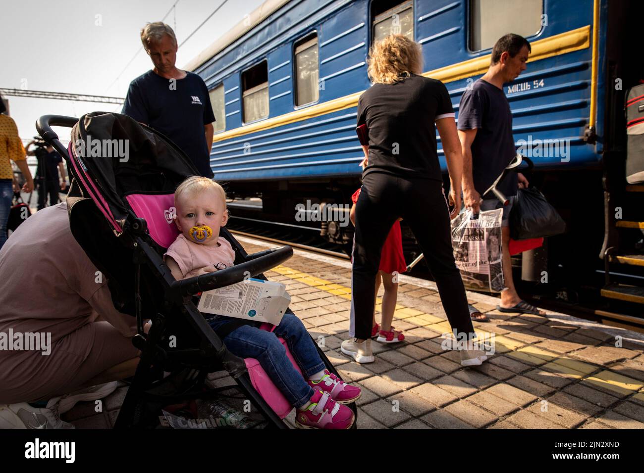 Pokrowsk, Oblast Donezk, Ukraine. 2. August 2022. Ein Baby, das im Kinderwagen sitzt, wartet auf den Evakuierungszug mit seinen Eltern am Bahnhof Pokrovsk. Inmitten der intensivierten Kämpfe im östlichen Teil der Ukraine intensiviert die Ostukraine nun ihre zivile Evakuierung, da Millionen ukrainischer Familien aus dem immer näher rückt Krieg evakuiert wurden, da viele von ihnen in den westlichen Teil des Landes verlagert werden.Laut den Vereinten Nationen werden die meisten von ihnen in den Westen des Landes umgesiedelt. Mindestens 12 Millionen Menschen sind seit dem russischen Einmarsch in die Ukraine aus ihren Häusern geflohen, während sieben Millionen Menschen sind Stockfoto