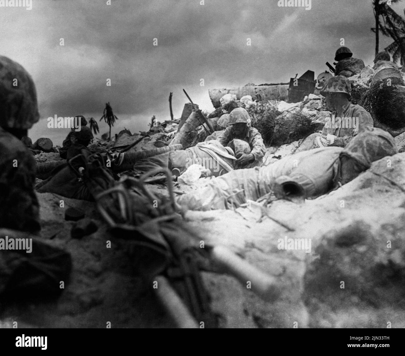 Marineinfanteristen decken sich unter den Toten hinter einer Meeresmauer am Red Beach #3, Tarawa. Die Landungen auf Tarawa waren Teil der US-Offensive gegen die Pazifikinseln, die Japan vor der Vorbereitung eines Angriffs auf das japanische Festland durchgeführt hatte. Stockfoto