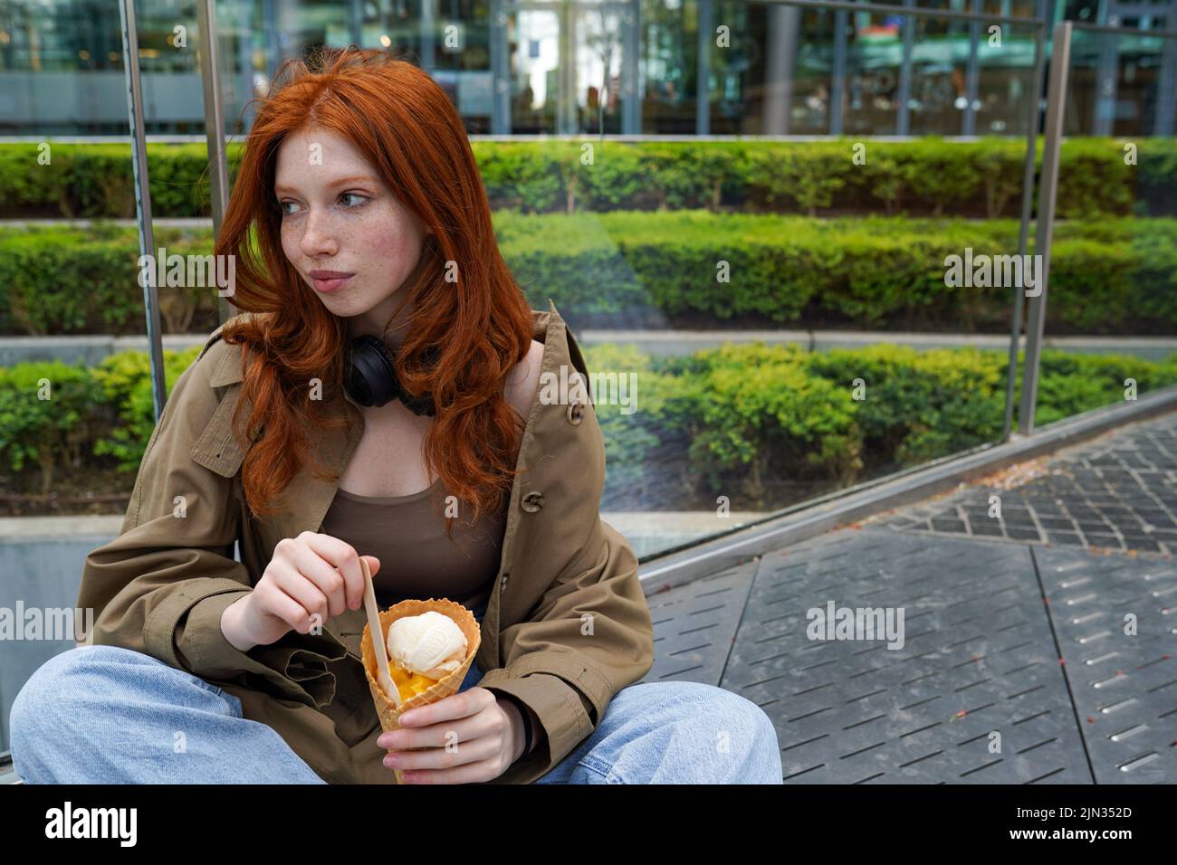 Cooles Teenager-Hipster-Mädchen, das Eis auf der städtischen Straße der Großstadt isst. Stockfoto