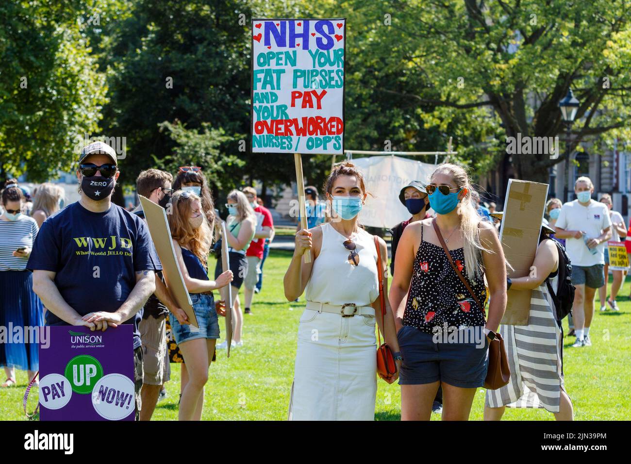 Plakat mit Protestierenden sind abgebildet, während sie an einer Demonstration und protestmarsch der NHS-Arbeiter ‘Pay Justice’ in Bristol, 8th. August 2020, teilnehmen Stockfoto
