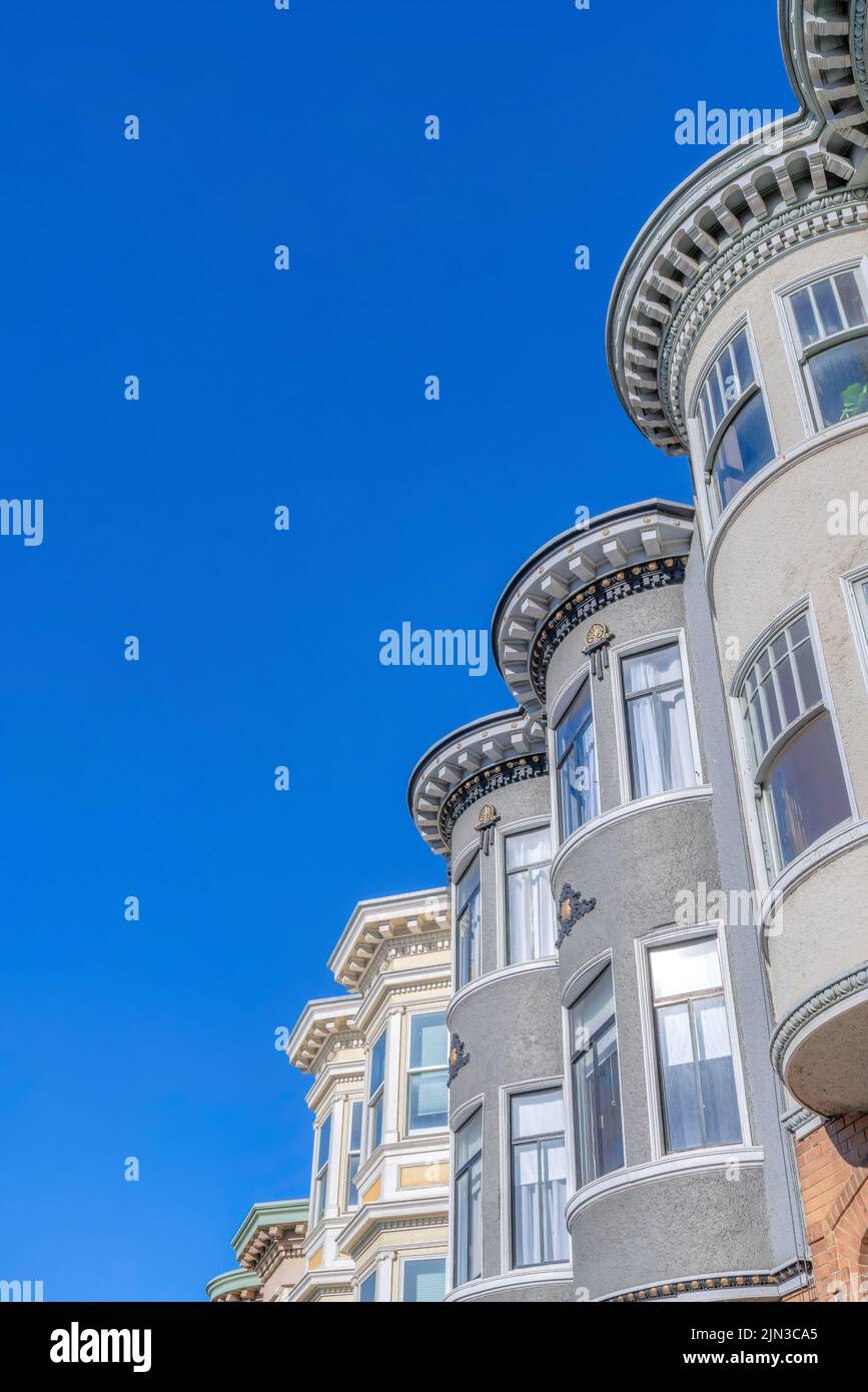 Viktorianische Stadthäuser mit dekorativem Fries und Gebiss in einem niedrigen Winkel Blick auf San Francisco, CA. Stadthäuser außen mit geschwungenen Fensterwänden und Dekor Stockfoto