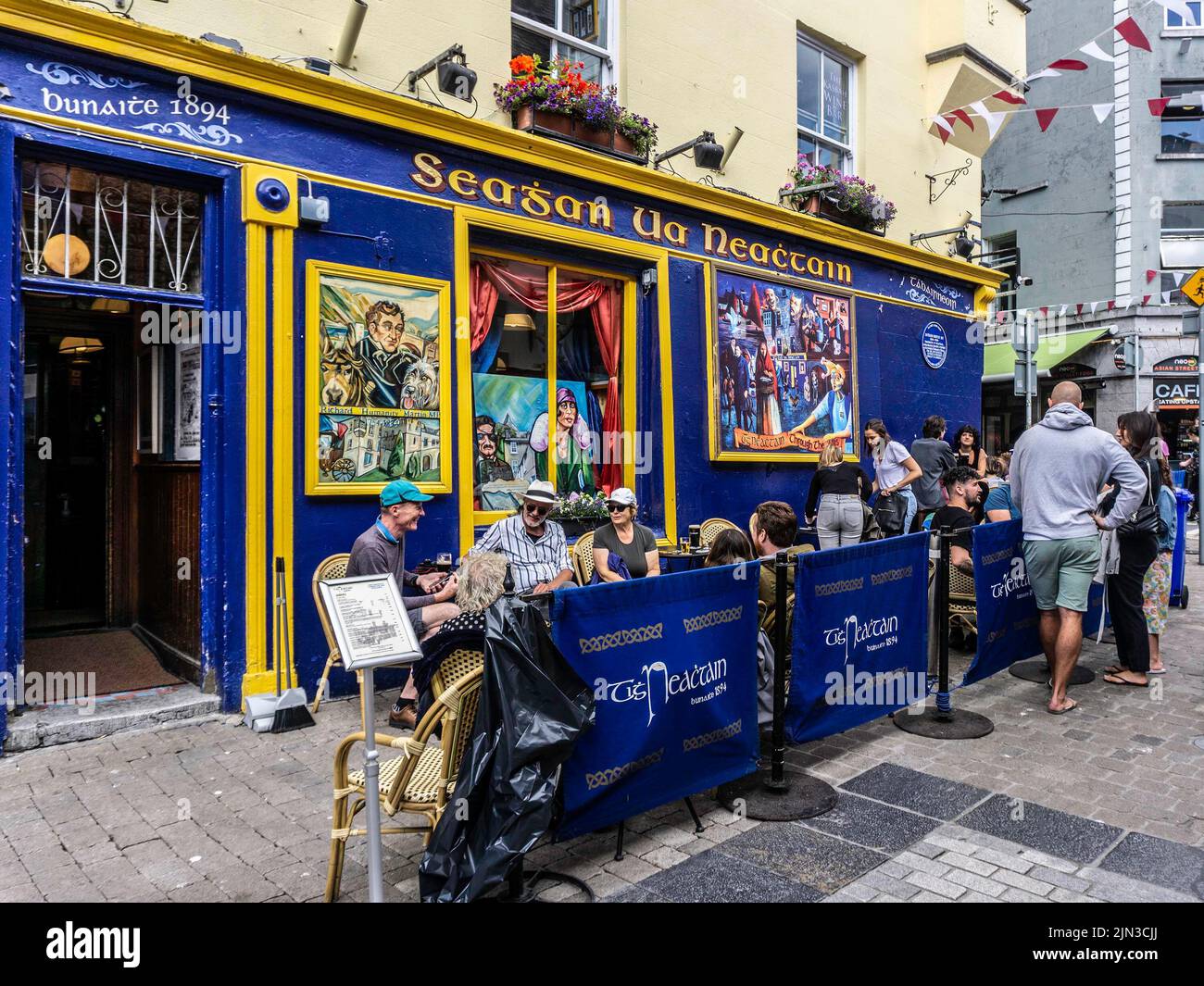 Menschen, die außerhalb von Seaghan UA Neachtain in Galway, Irland, speisen. Ein öffentliches Haus seit 1894. Serviert Mittagessen und Pub-Gerichte. Stockfoto