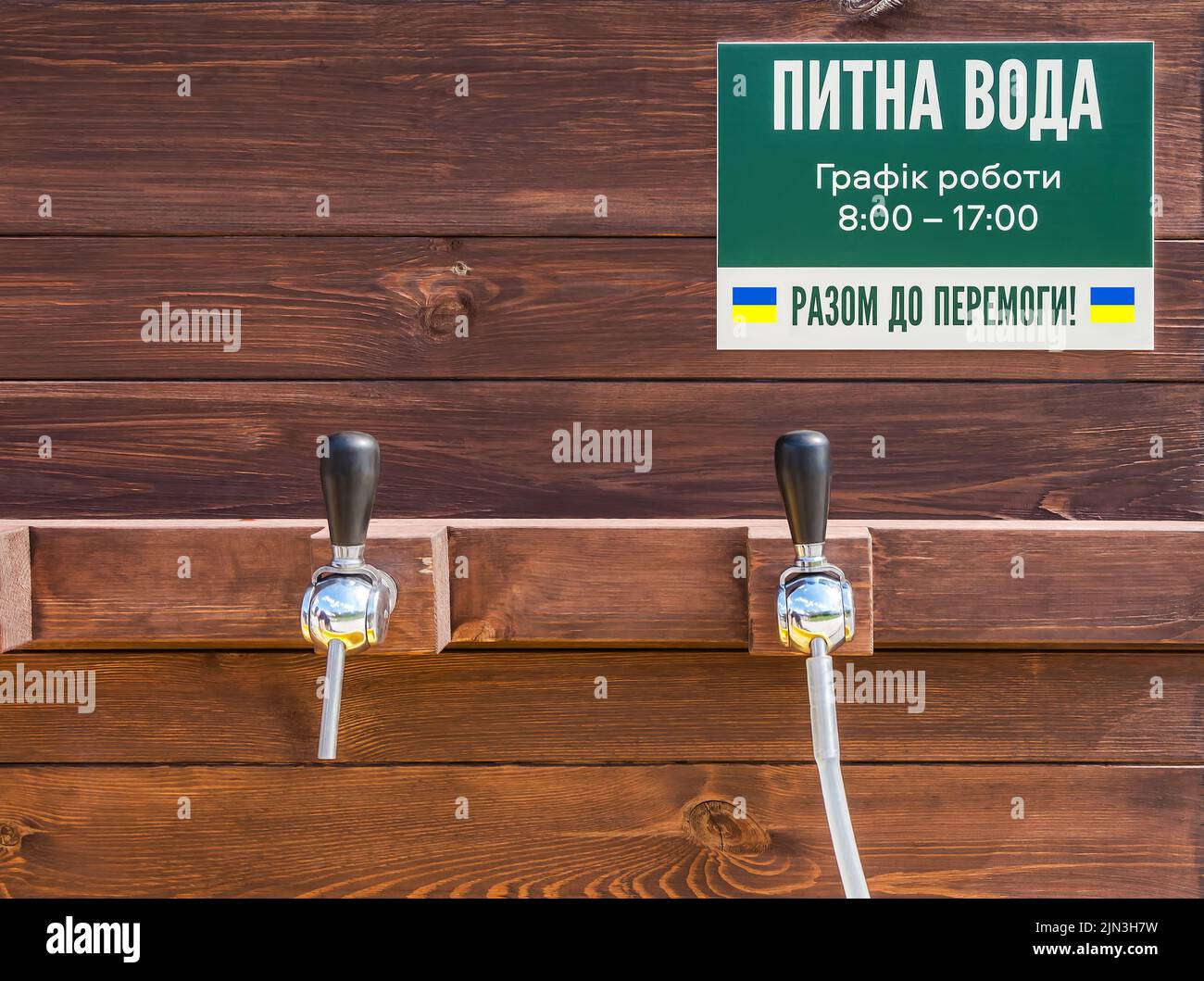 Freie Stelle gefiltertes Wasser für ukrainische Menschen, die ihre Häuser als Folge der Bombardierung der russischen Invasionsarmee im Jahr 2022 verloren haben. Inschrift - Drinkin Stockfoto
