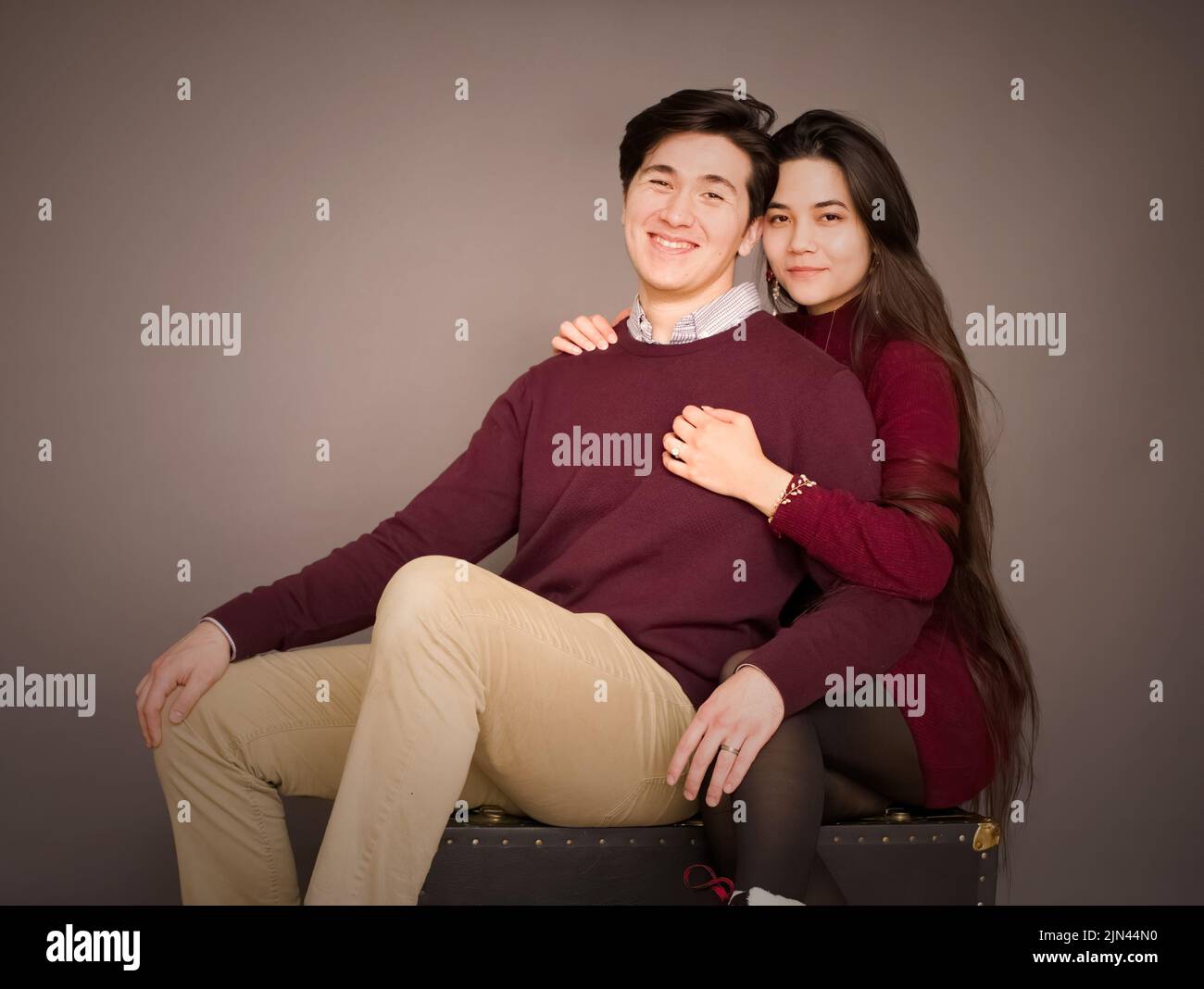 Attraktive junge Biracial Paar in burgunderfarbenen Pullover posiert für Porträt Stockfoto