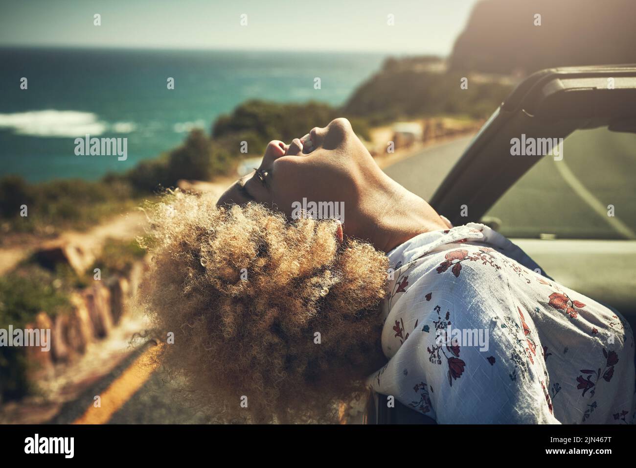 Lassen Sie Ihre Gedanken auf eine Reise gehen. Eine junge Frau, die sich auf einem Roadtrip amügt, wird heiß geschnitten. Stockfoto
