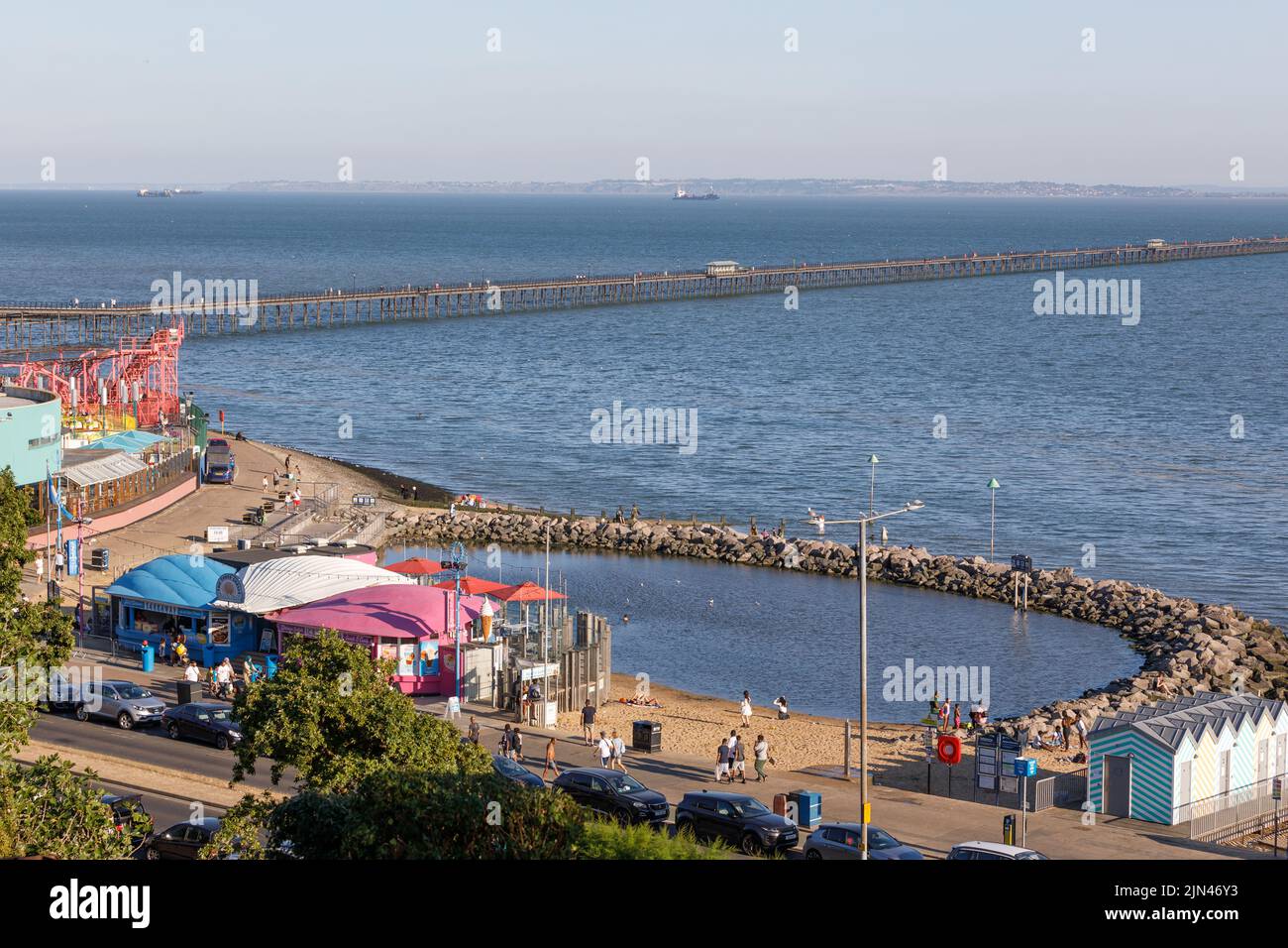 Three Shells Beach, eine von Menschen geschaffte Badelagune, Southend Pier und Strandpromenade sowie Schiffe in der Themse-Mündung mit der Kent-Küste im Hintergrund Stockfoto